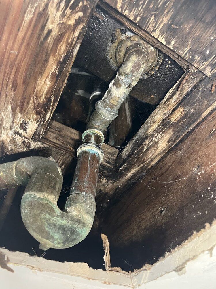 Heavily corroded lines exposed through a ceiling opening