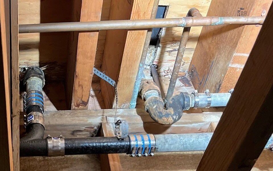 Cast iron drain and copper supply in a joist bay